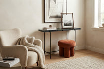 LOOP pouf in Saffron beside a console table in a living room