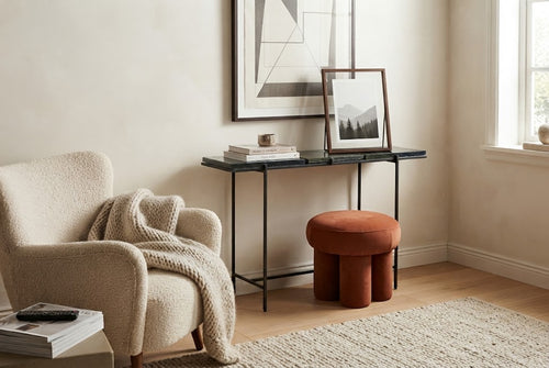 LOOP pouf in Saffron beside a console table in a living room